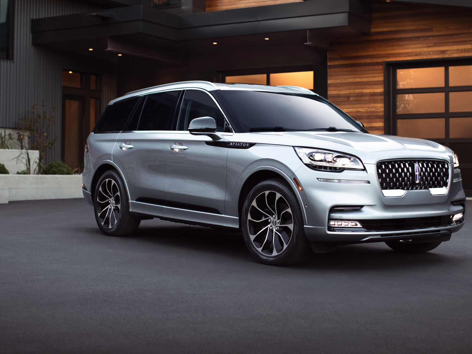 Серебристый внедорожник Lincoln Aviator Grand Touring, 2020 года на фоне дома