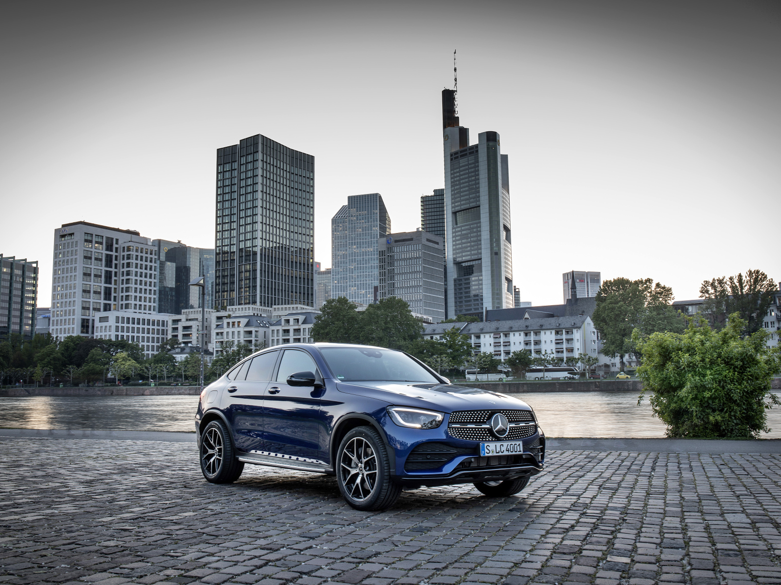 Синий автомобиль Mercedes-Benz GLC-Class на фоне небоскребов