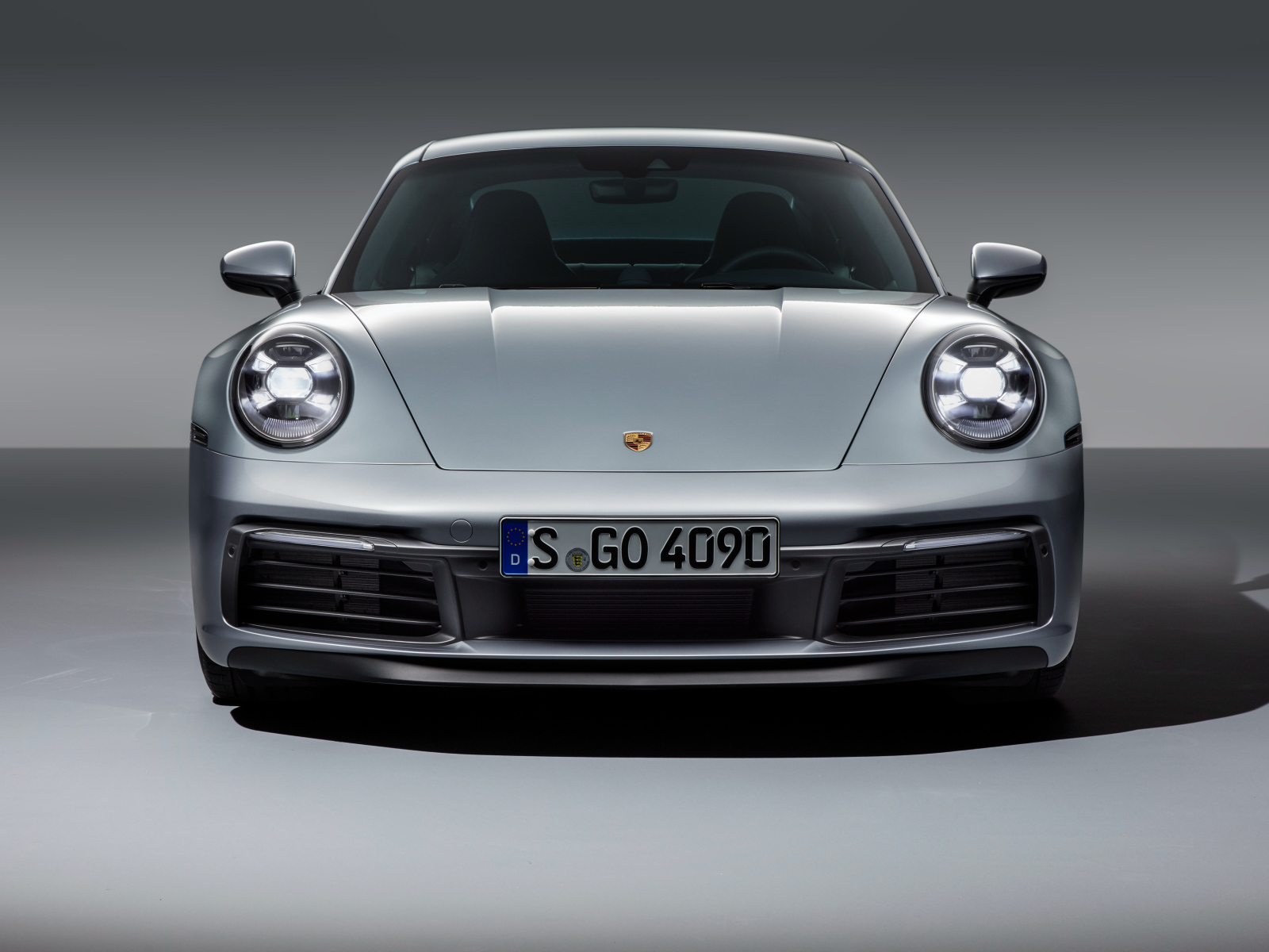 Серебристый автомобиль Porsche 911 Carrera 4S 2019 вид спереди