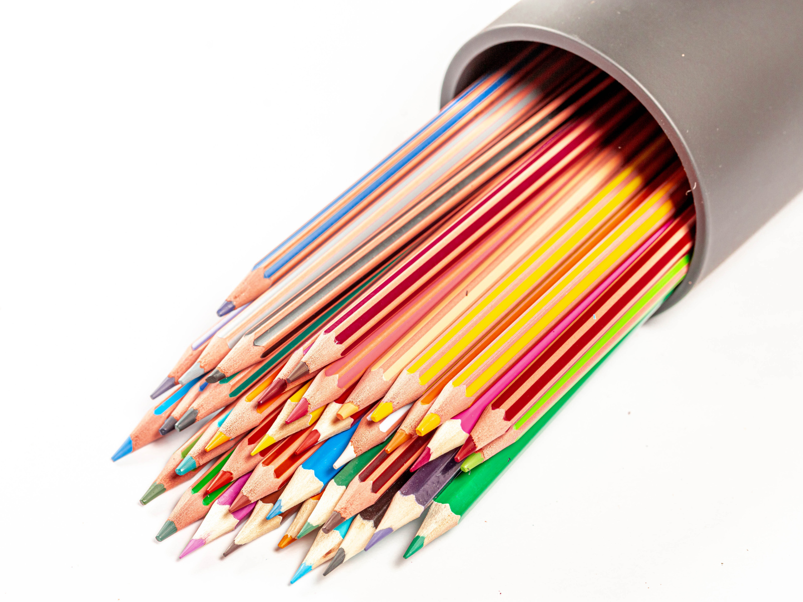 Много разных карандашей в пенале на белом фоне