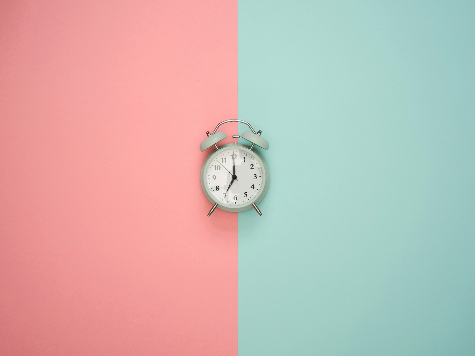 Серый будильник на разноцветном фоне