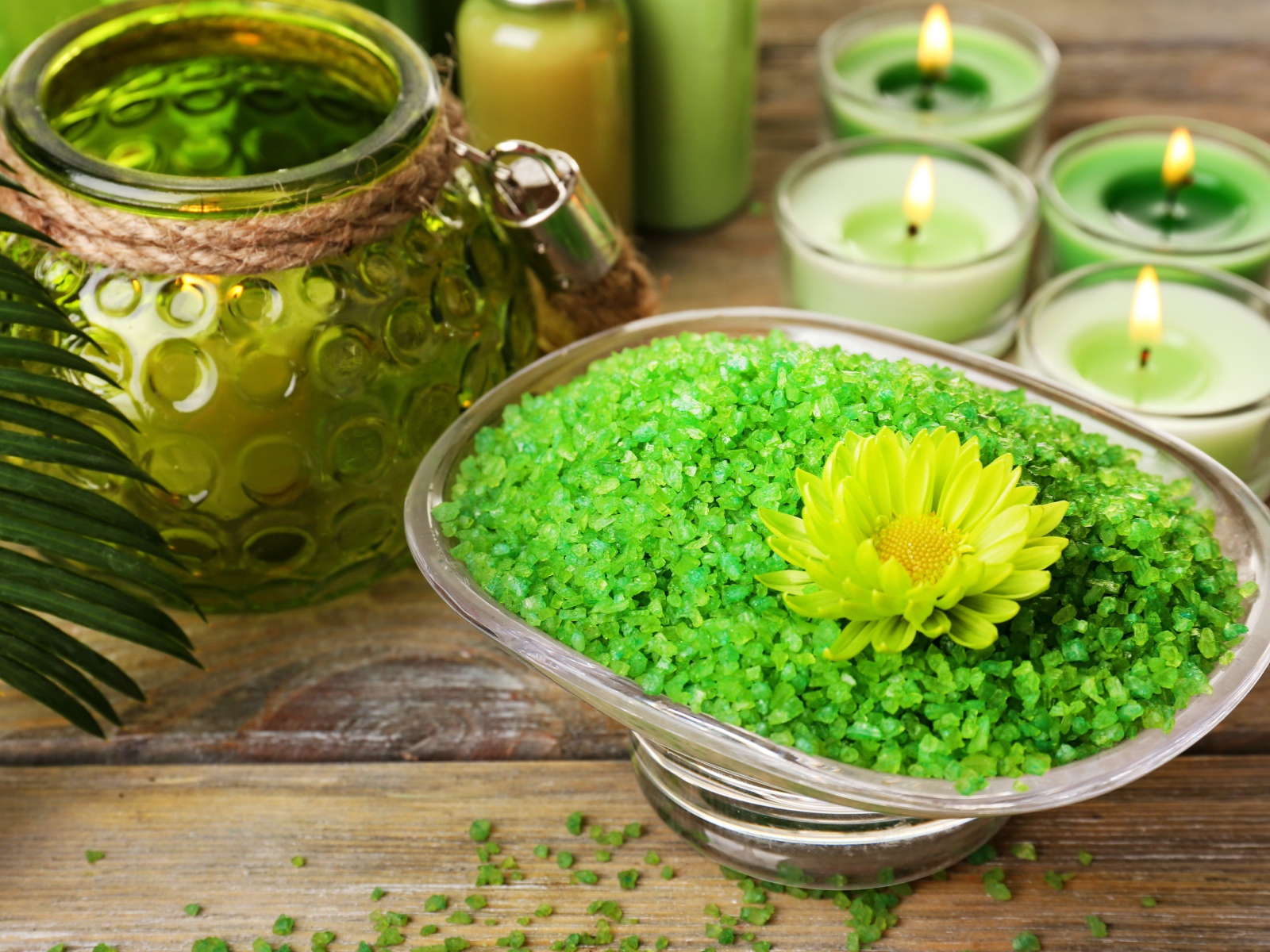 Зеленая ароматная морская соль на столе с зажженными свечами