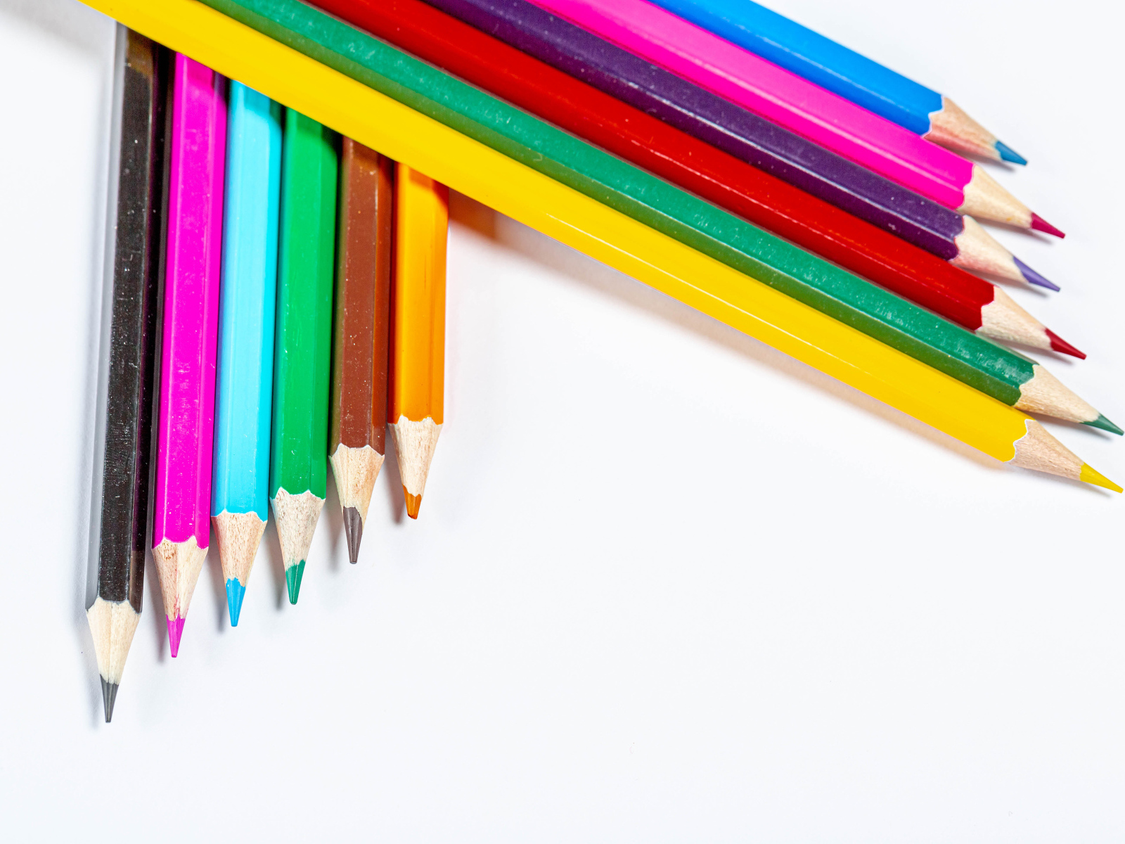 Разноцветные острые карандаши на белом фоне