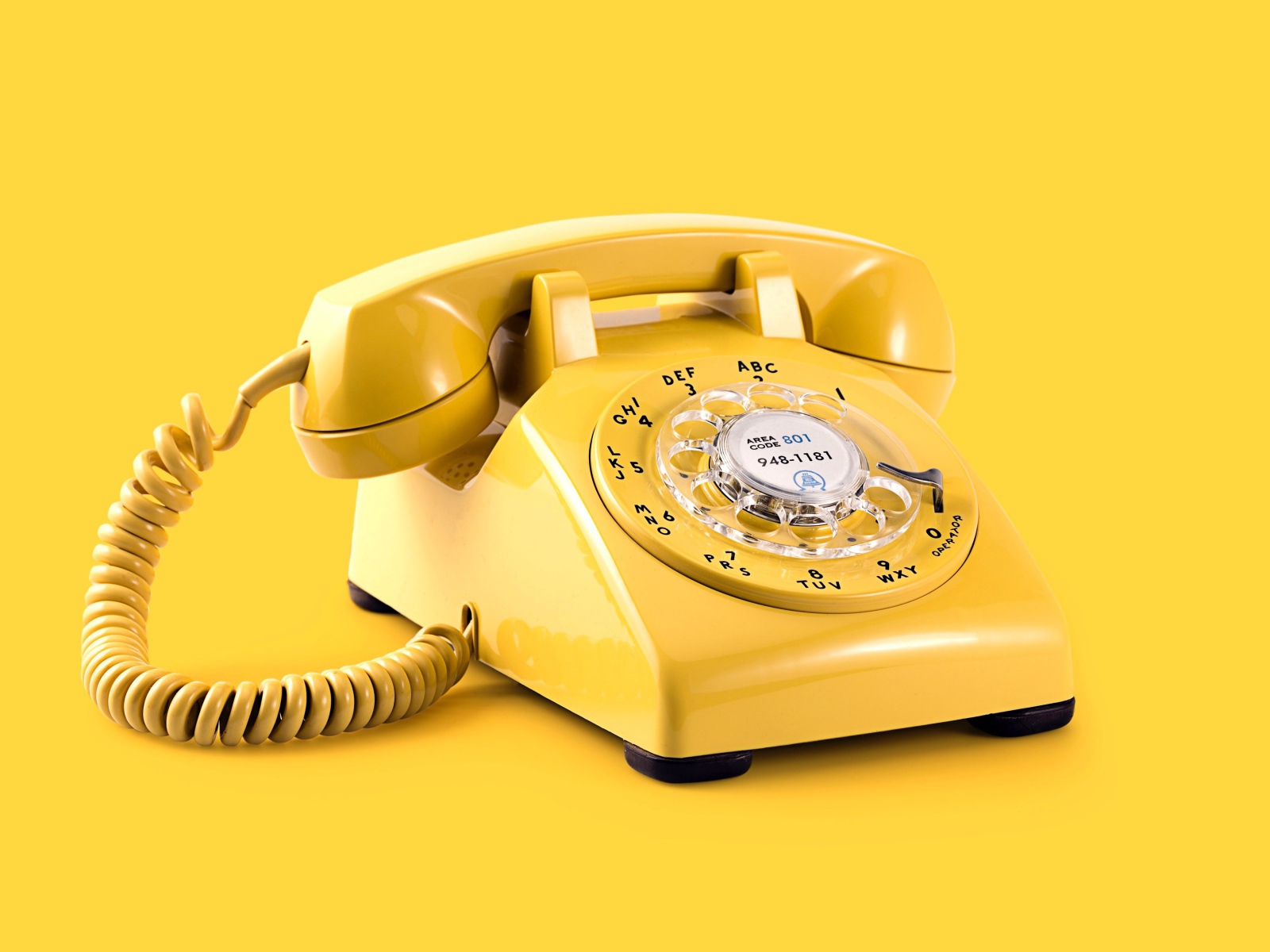 Старый желтый телефон на желтом фоне