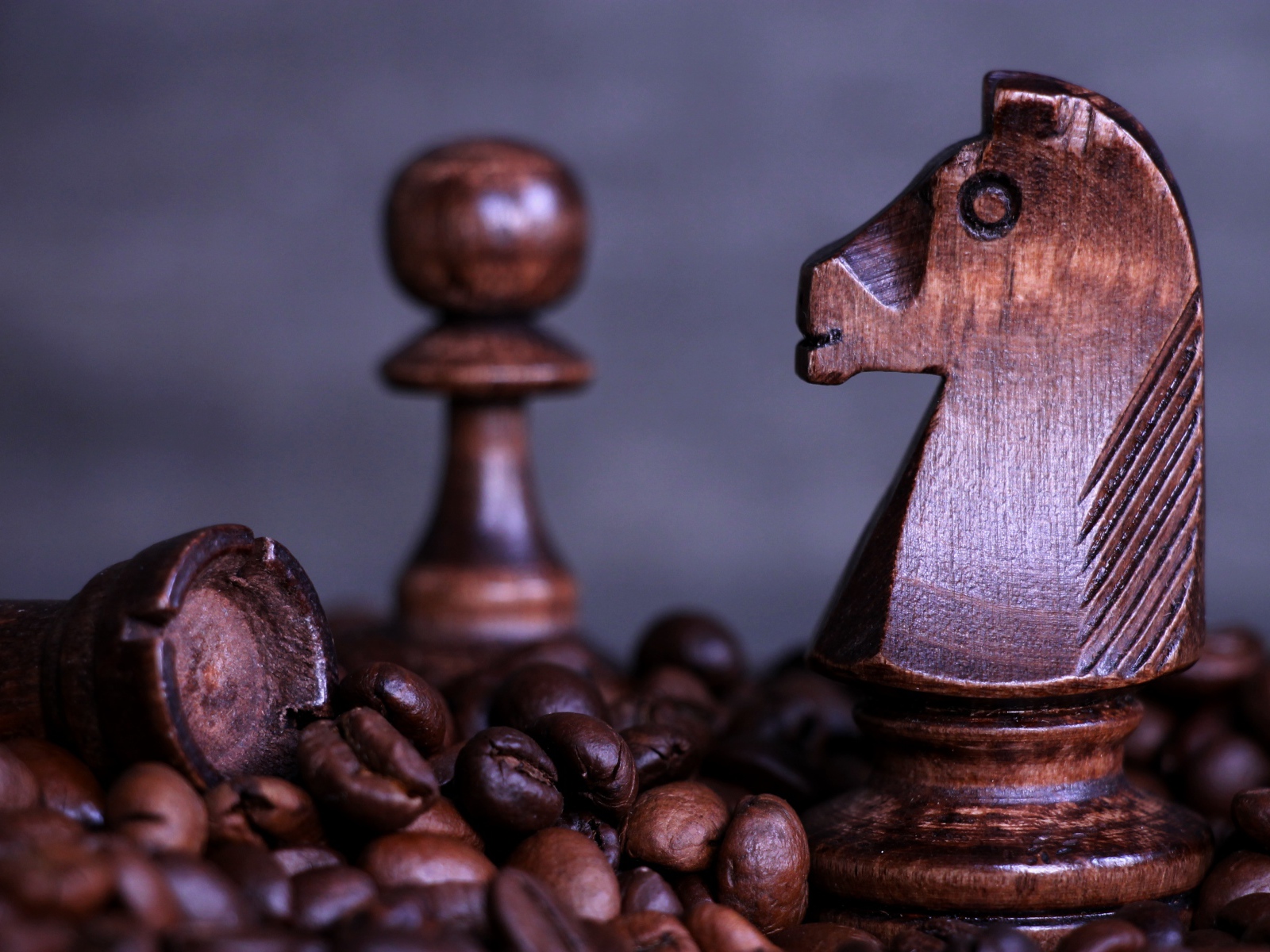 Деревянные шахматные фигуры стоят на кофейных зернах 