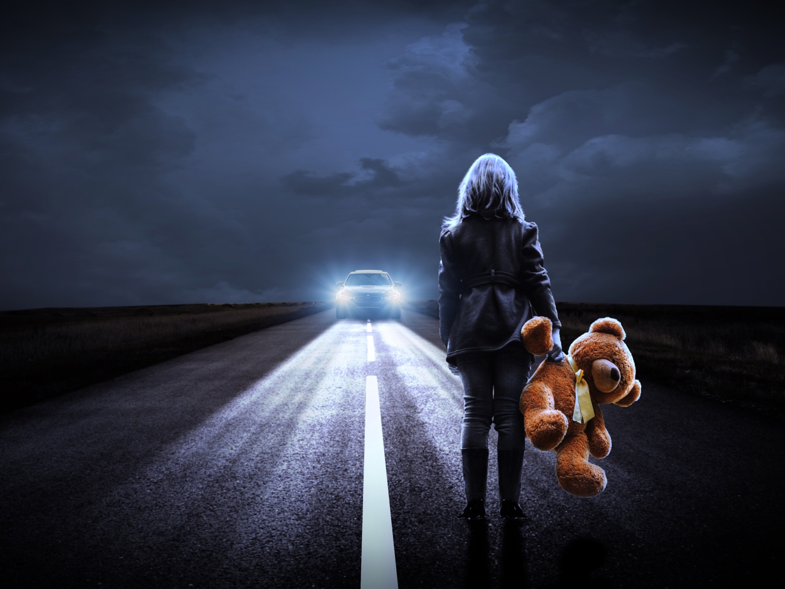 Girl stands on the road with a toy bear