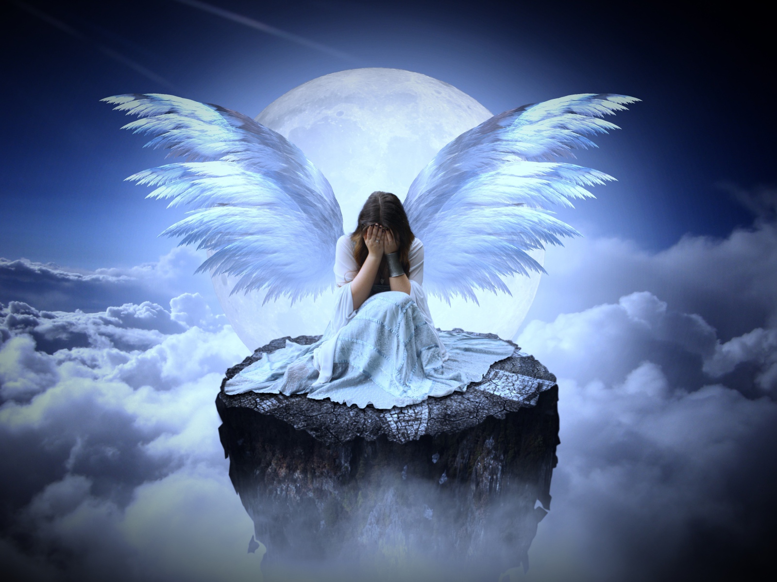 Девушка с крыльями ангела сидит на камне в облаках