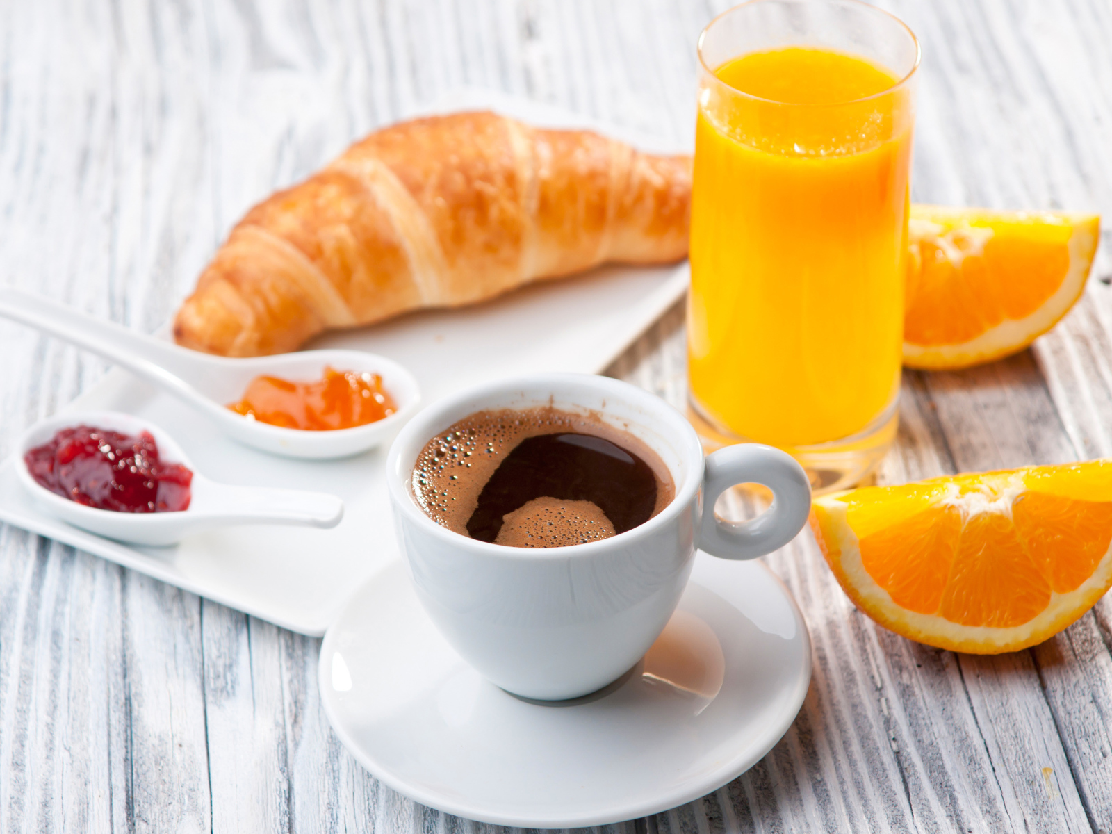 Чашка кофе на столе с соком и круассаном