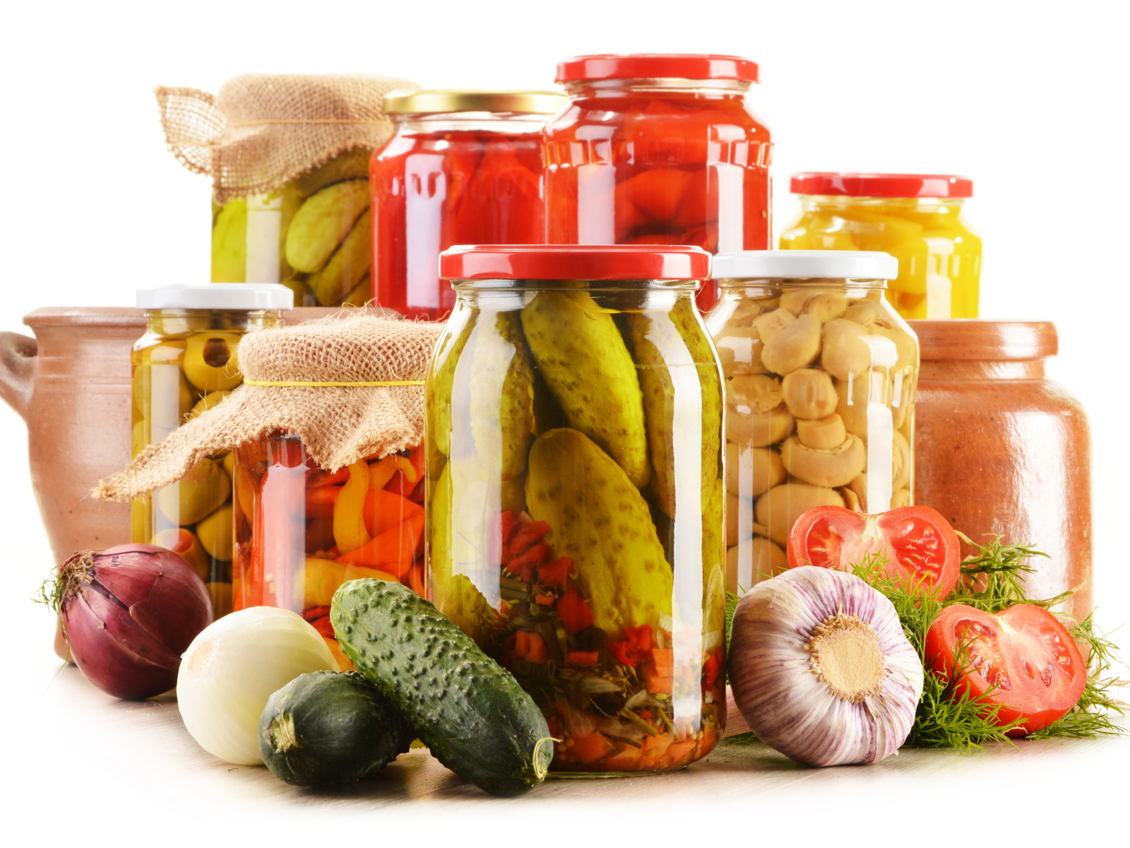 Консервация в банках на белом фоне с овощами