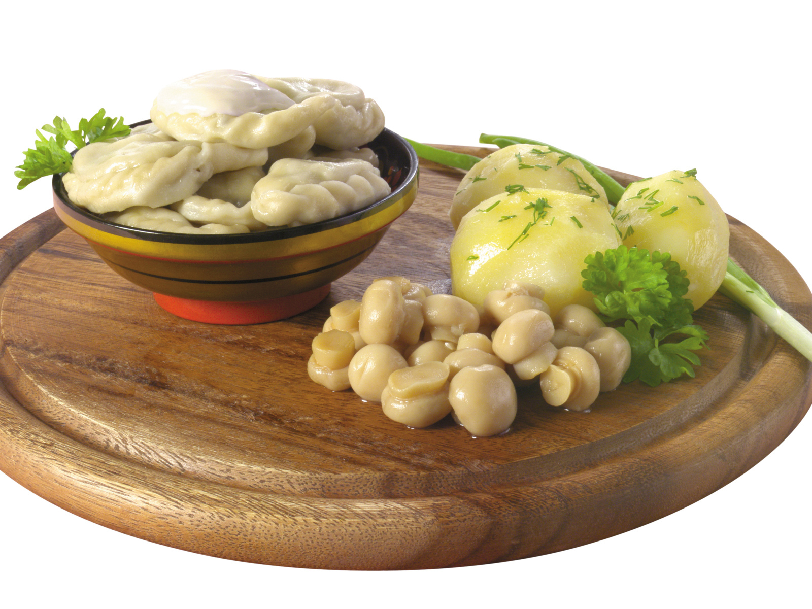 Вареники с грибами и вареной картошкой на деревянной доске на белом фоне