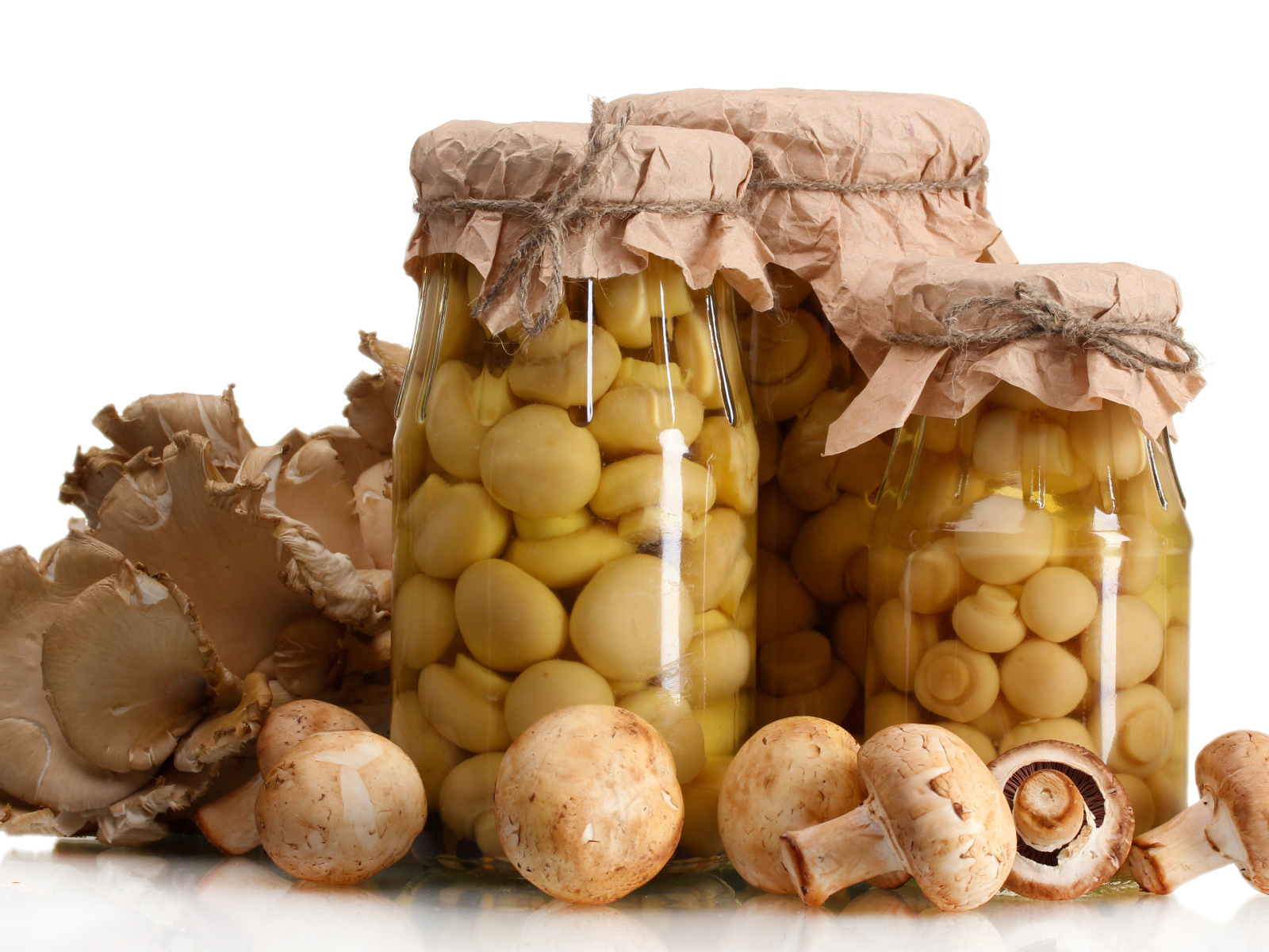 Маринованные шампиньоны в банках на белом фоне со свежими