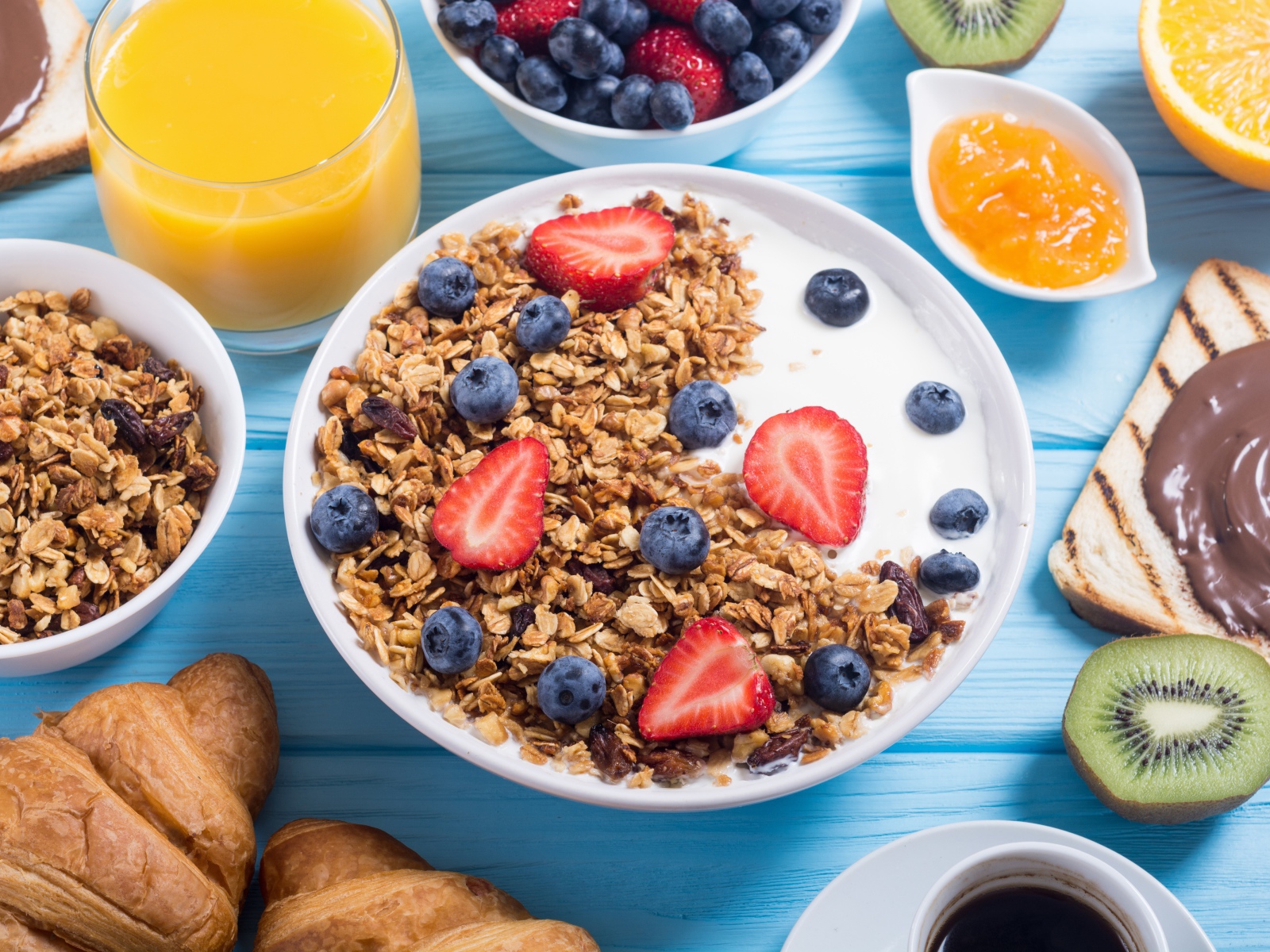 Мюсли с ягодами и молоком в тарелке на столе к завтраку