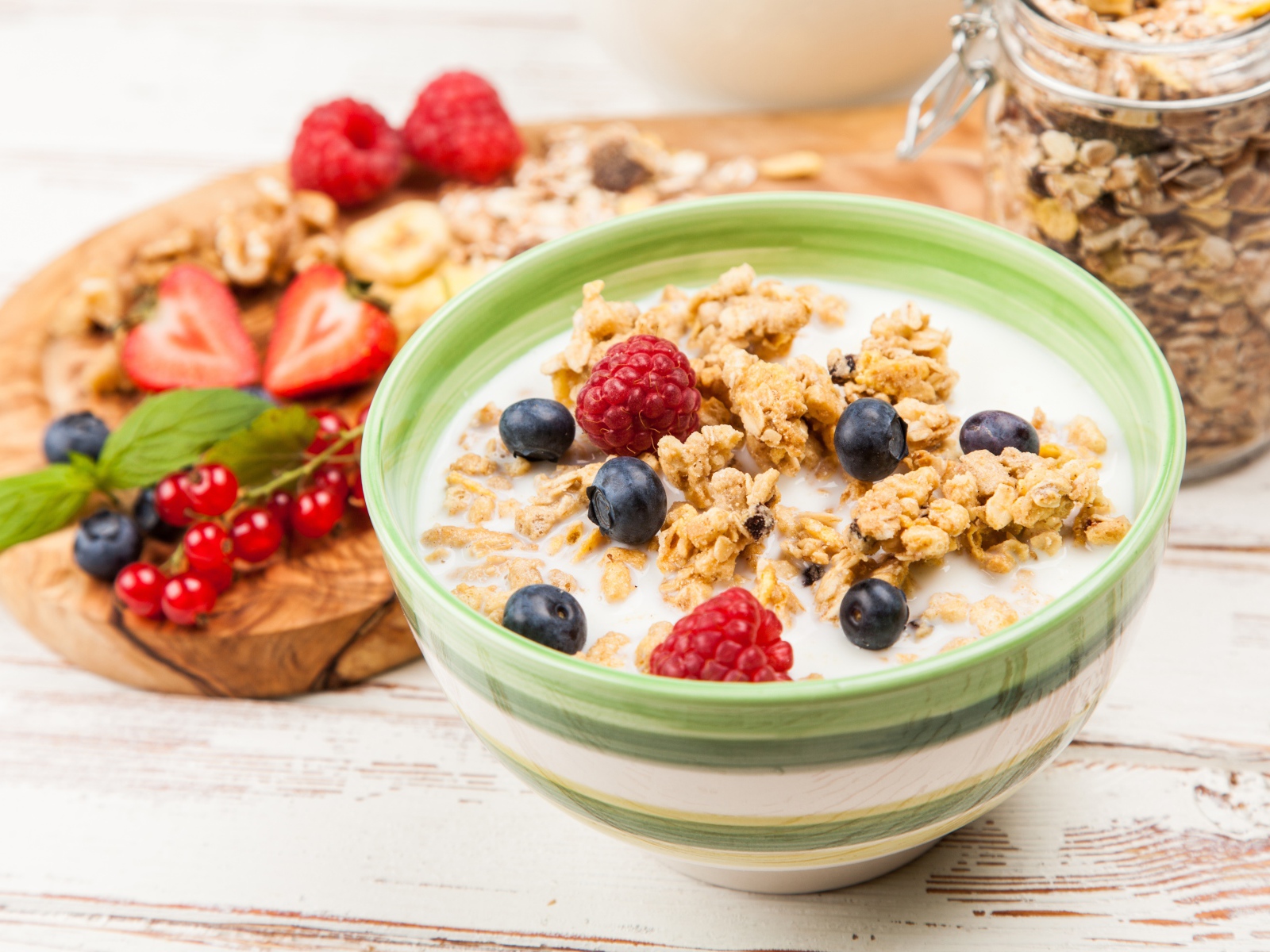 Мюсли с молоком и ягодами на столе к завтраку