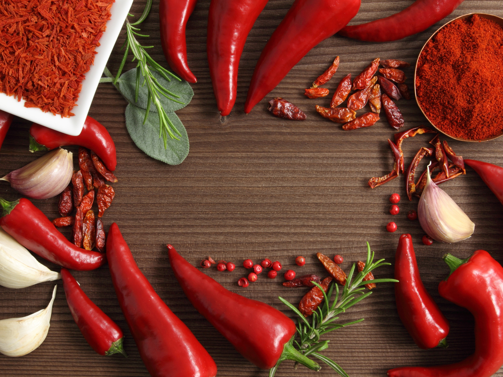 Красный перец с чесноком на деревянном столе