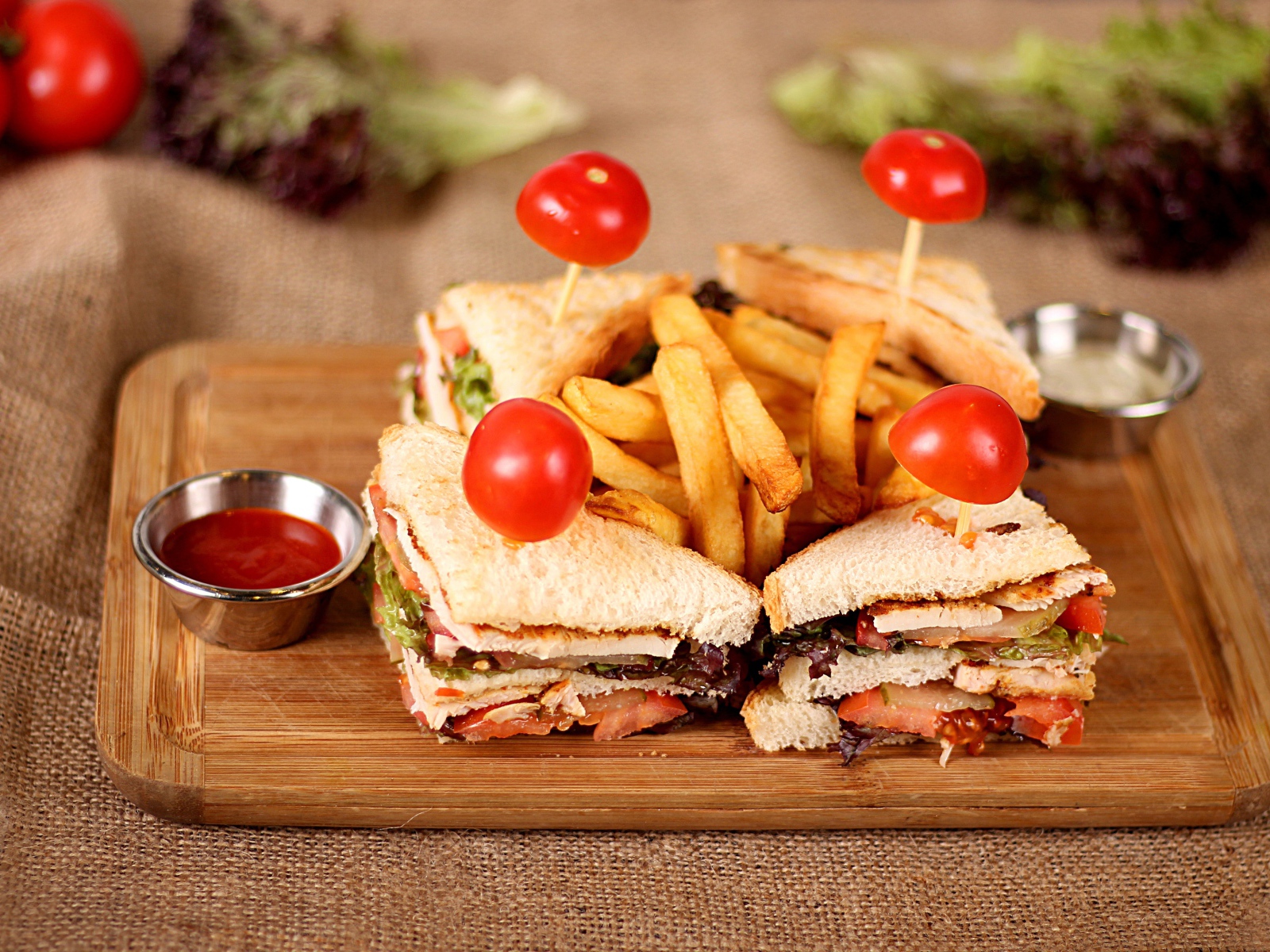 Сэндвичи на доске с картофелем фри и соусом