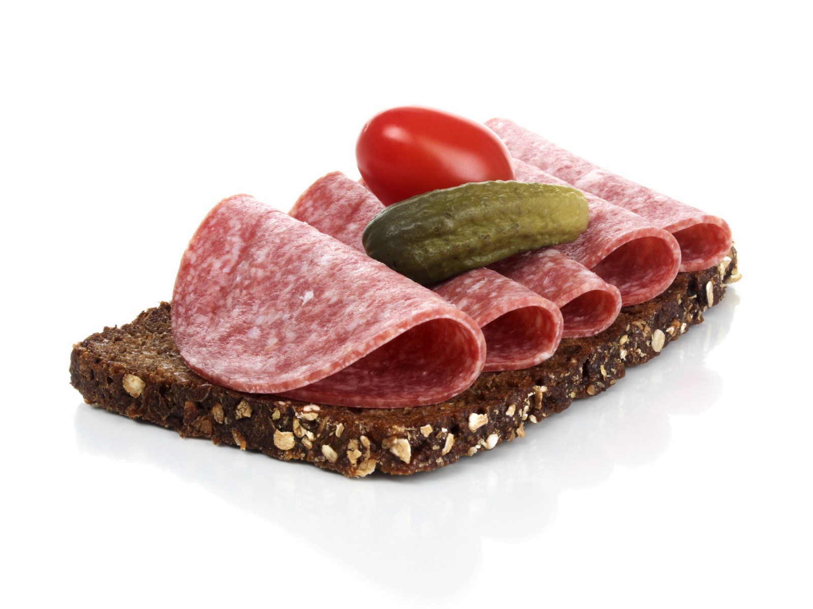 Бутерброд с черным хлебом, колбасой, соленым огурцом и помидором на белом фоне