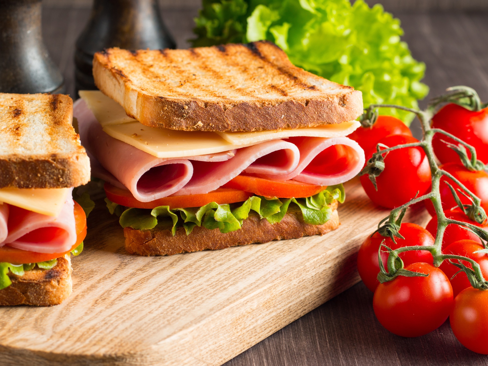 Бутерброды на столе с помидорами и листьями салата