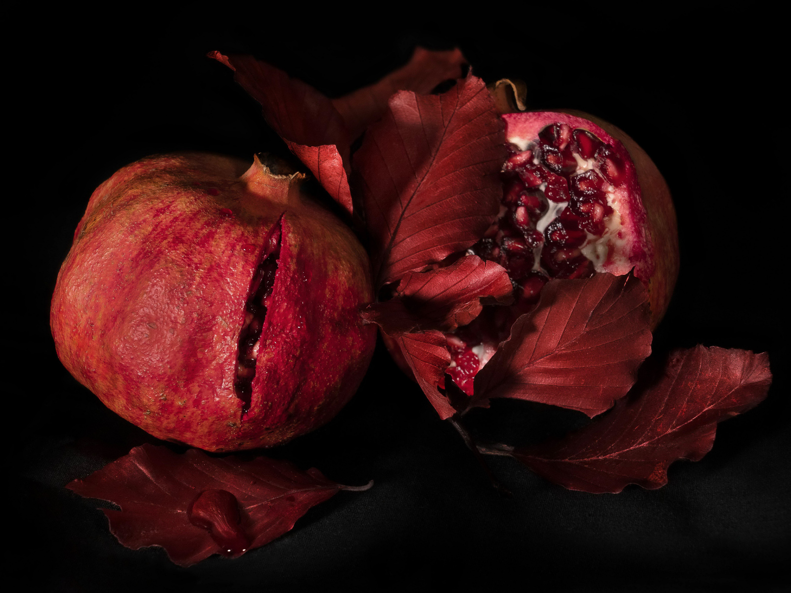 Два красных граната на черном фоне
