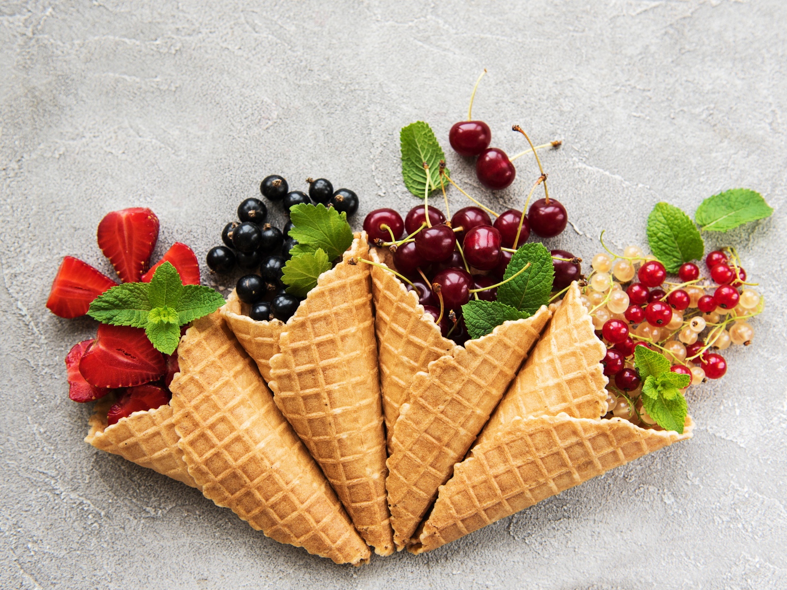 Вафельные рожки с ягодами на сером фоне