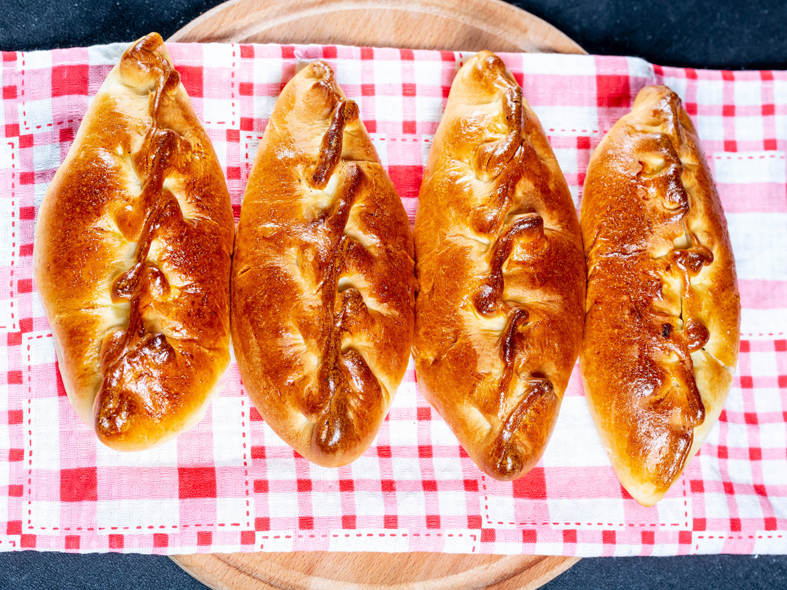 Аппетитные румяные пирожки лежат на полотенце 