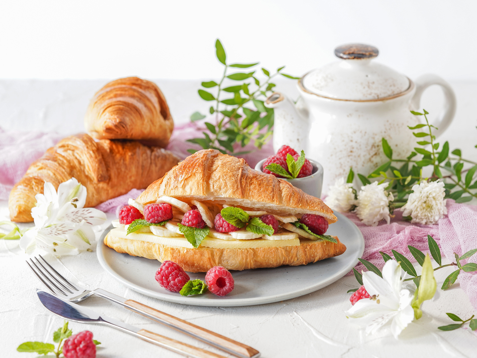 Бутерброд из круассана с ягодами малины и бананами