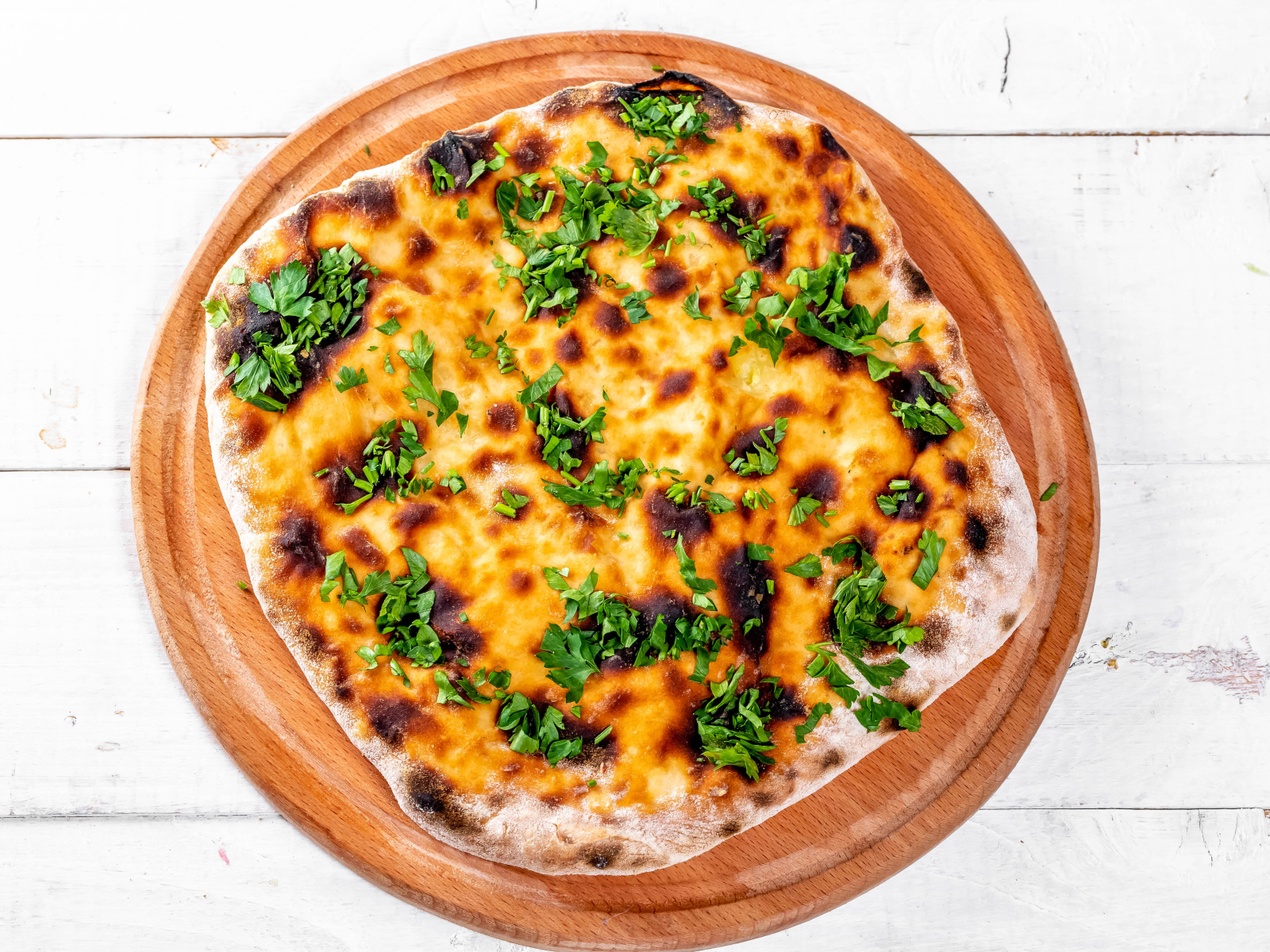 Пирог с сыром и зеленью на доске 