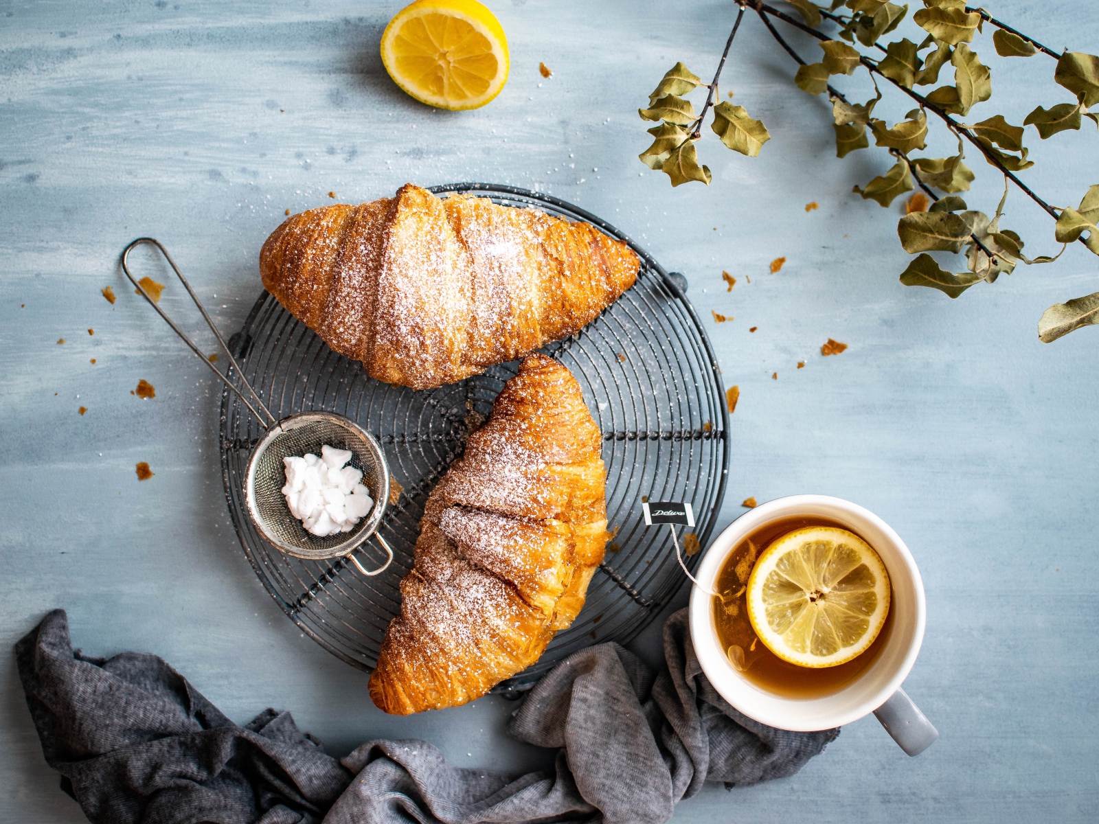 Два свежих круассана на столе с чаем