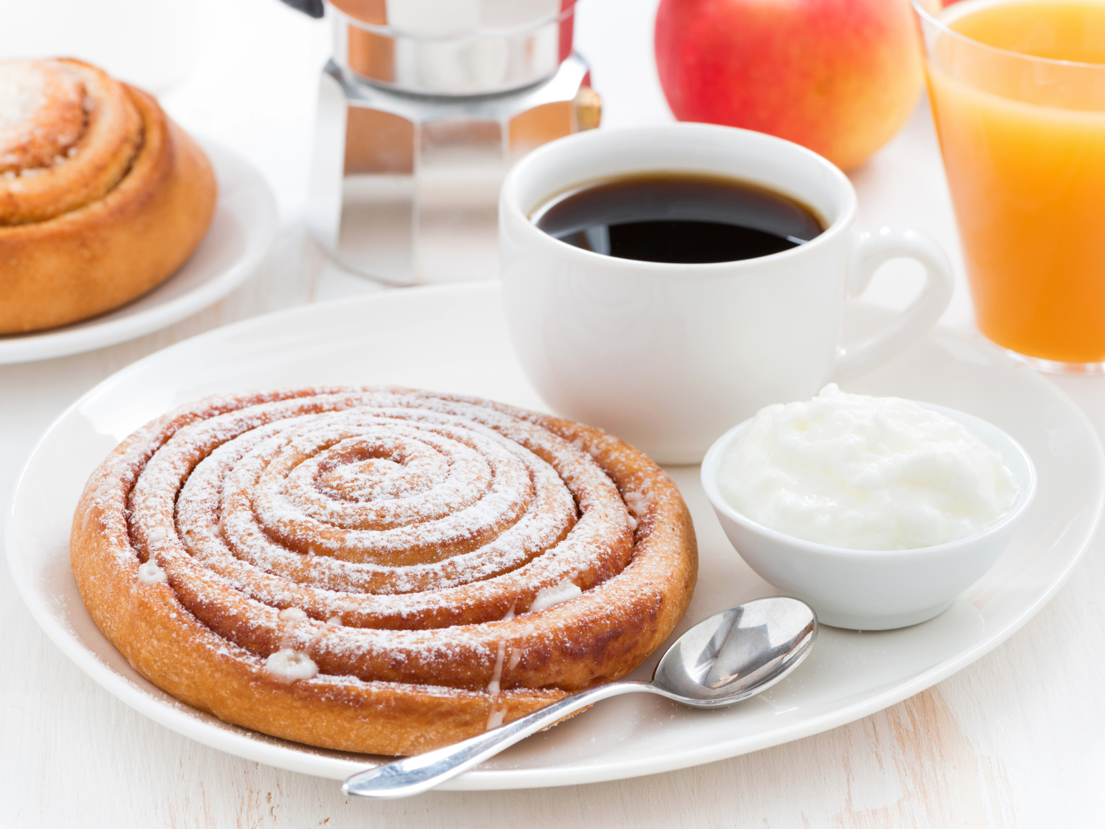 Чашка кофе на тарелке с выпечкой и сливками