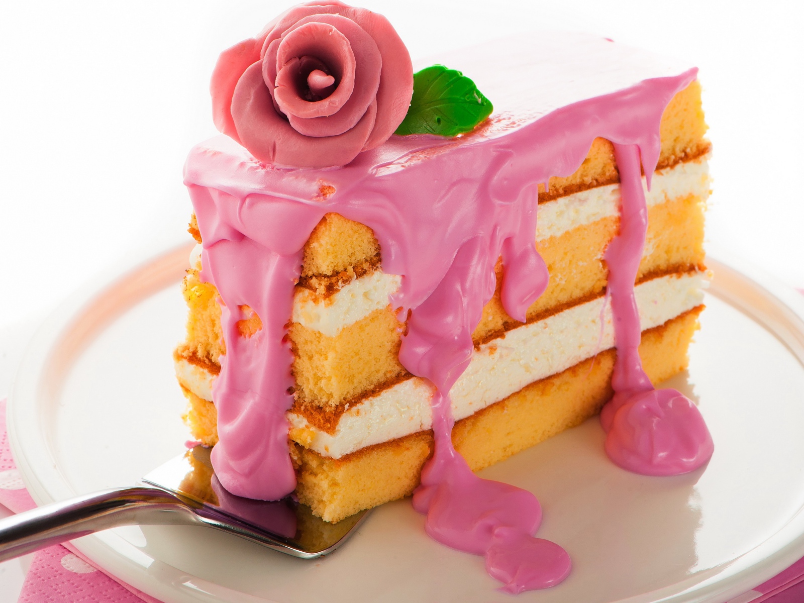 Кусок торта с розовым кремом и сахарном розой