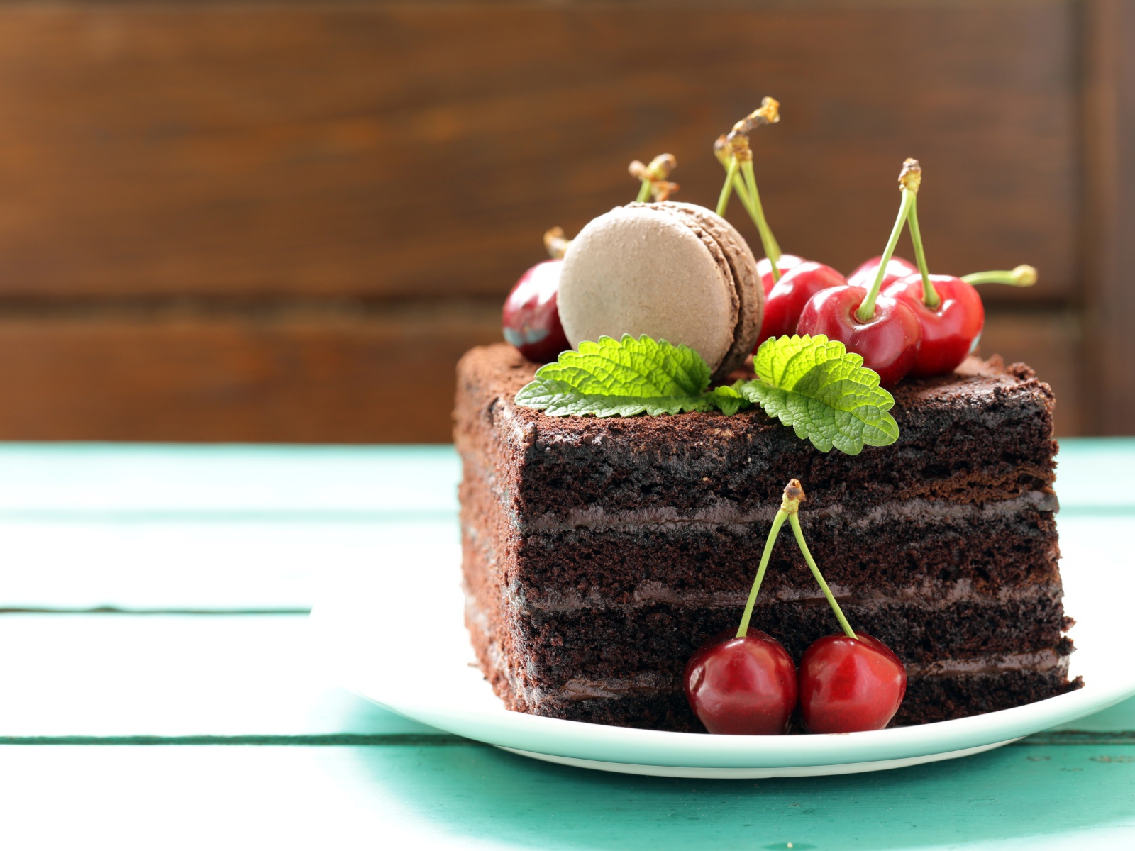 Кусок шоколадного торта с черешней и печеньем макарон