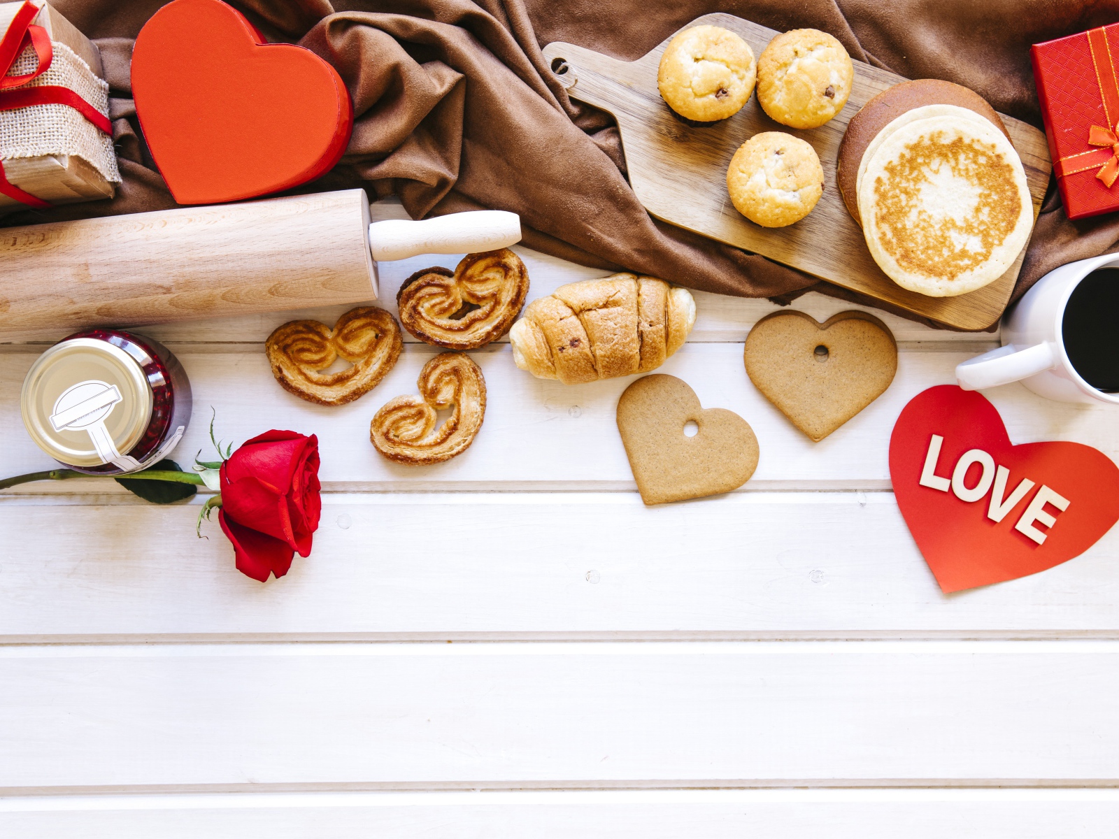 Аппетитная сладкая выпечка на столе с кофе, сердечками и подарками 