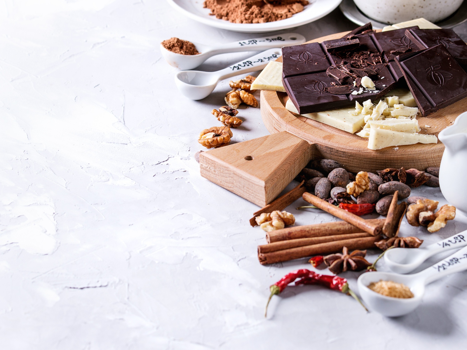 Черный и молочный шоколад на столе с орехами