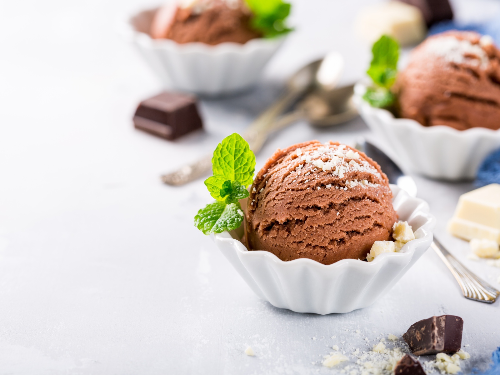 Шарик шоколадного мороженого с мятой на столе с шоколадом