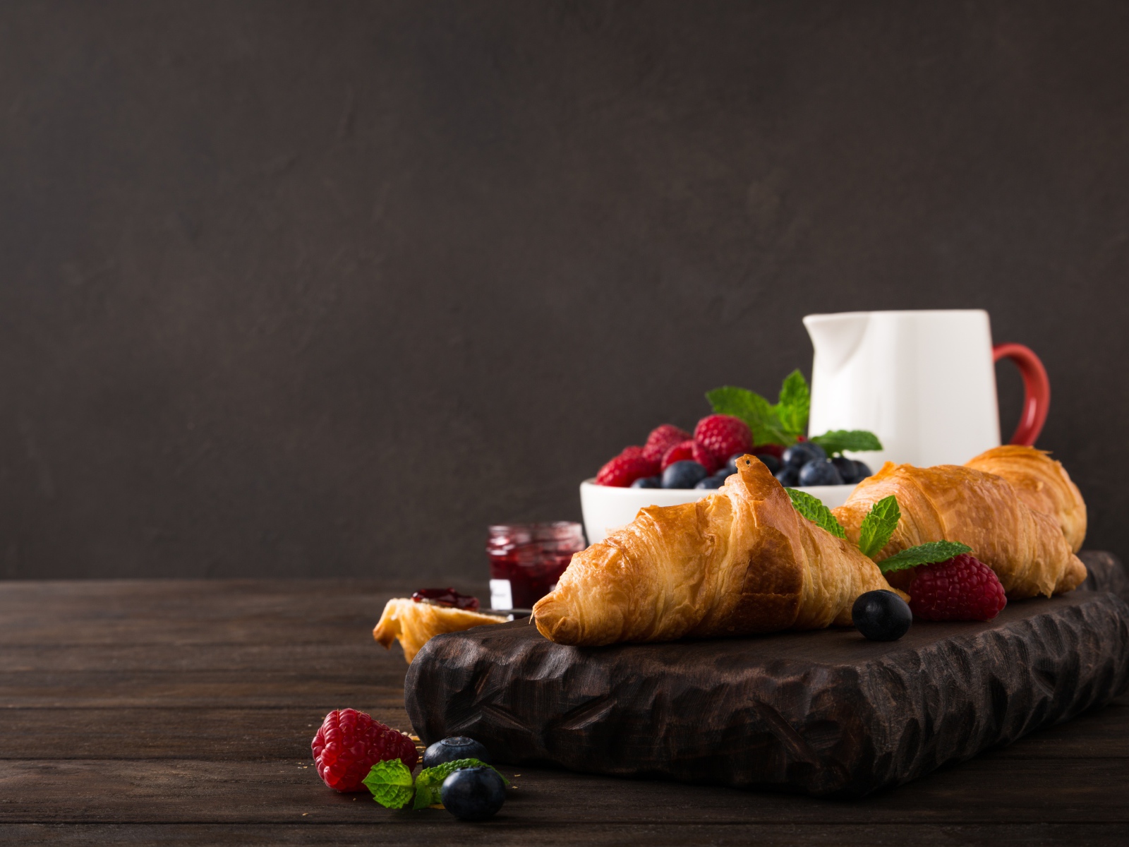 Круассаны на столе с ягодами и джемом 