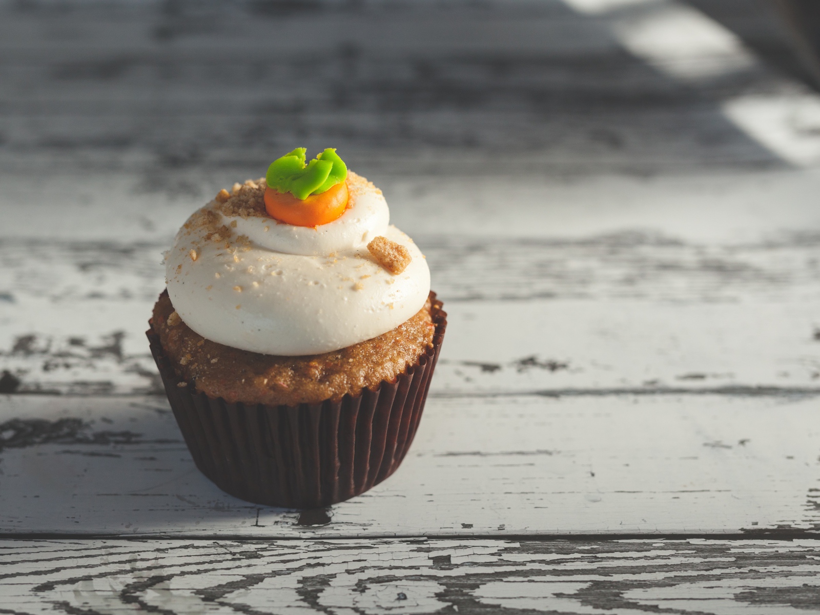 Вкусный сладкий кекс с кремом на деревянном столе 