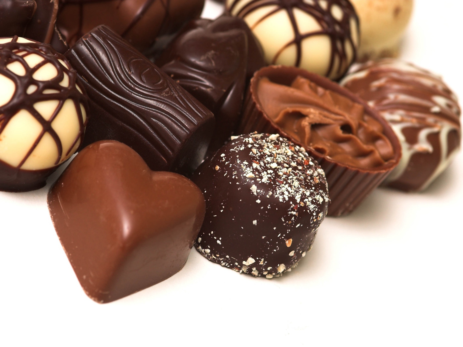 Разные шоколадные конфеты на белом фоне 