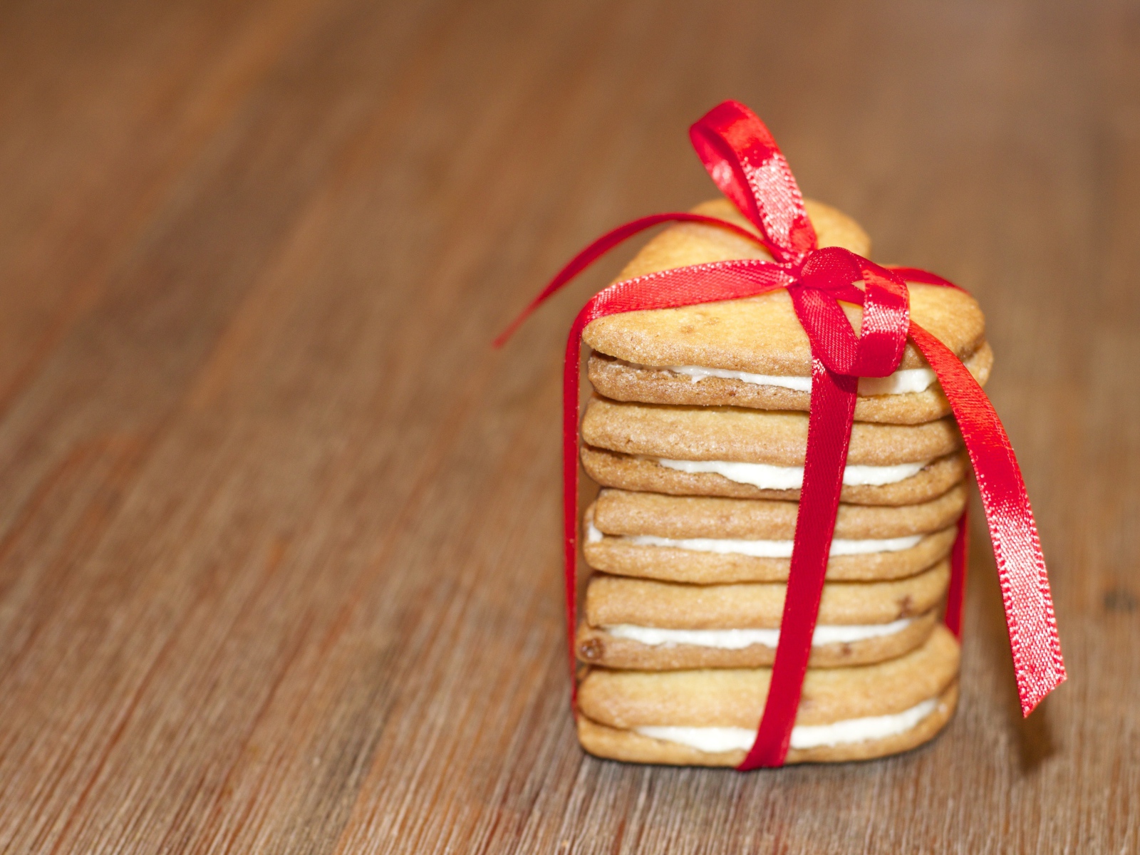 Печенье в форме сердца перевязано красной лентой 