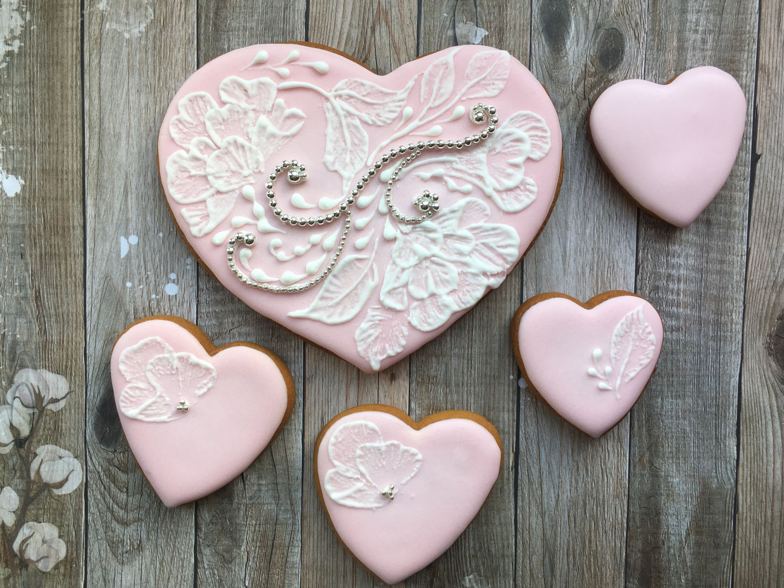 Печенье в форме сердца с розовой глазурью на столе