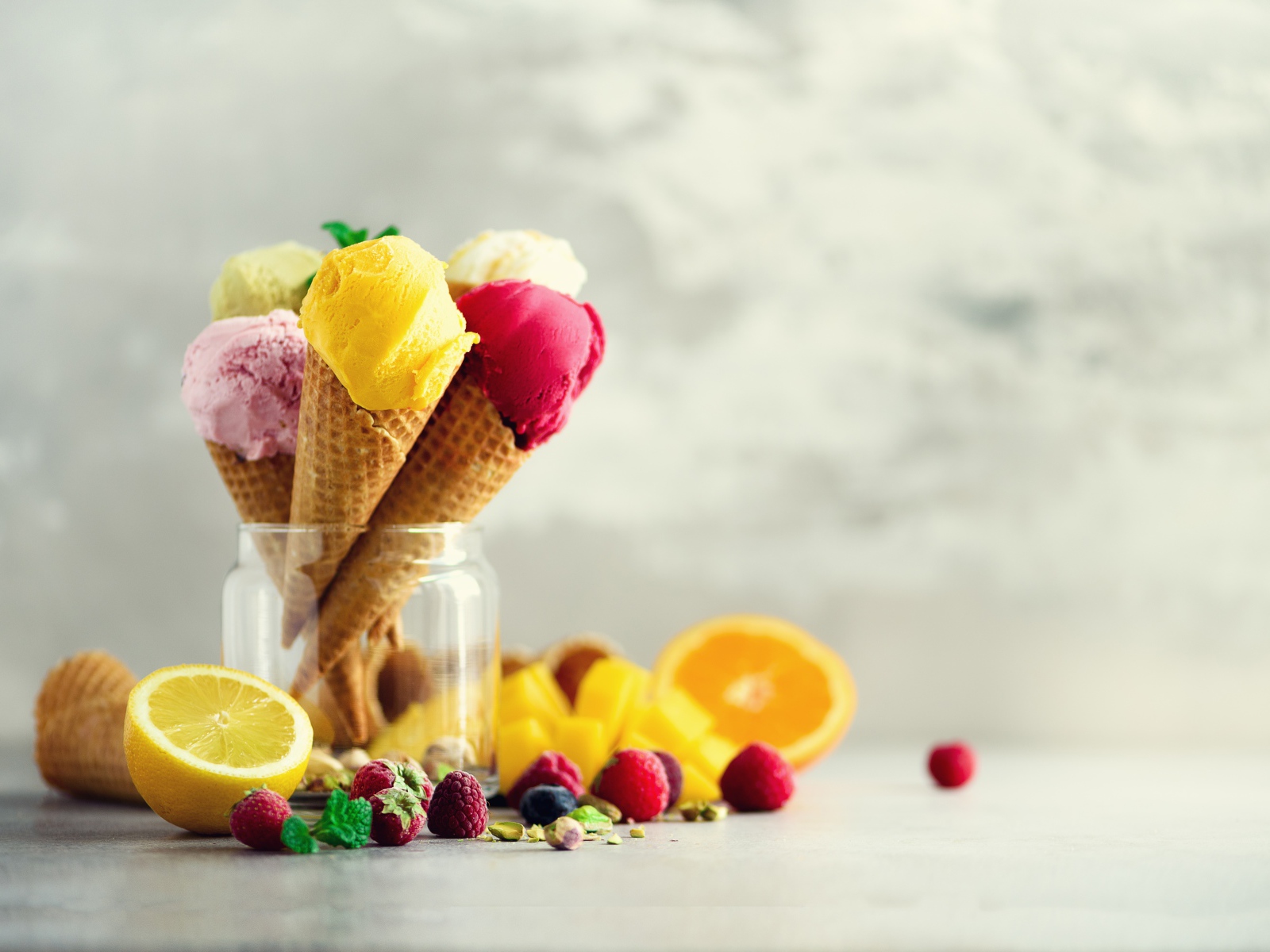Фруктовое мороженое в вафельных рожках на столе с ягодами и фруктами