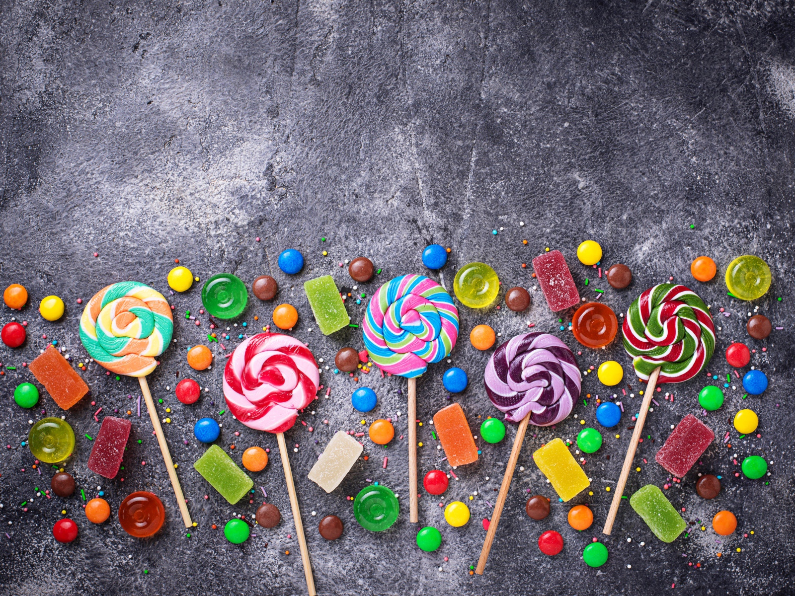 Разноцветные леденцы на сером столе