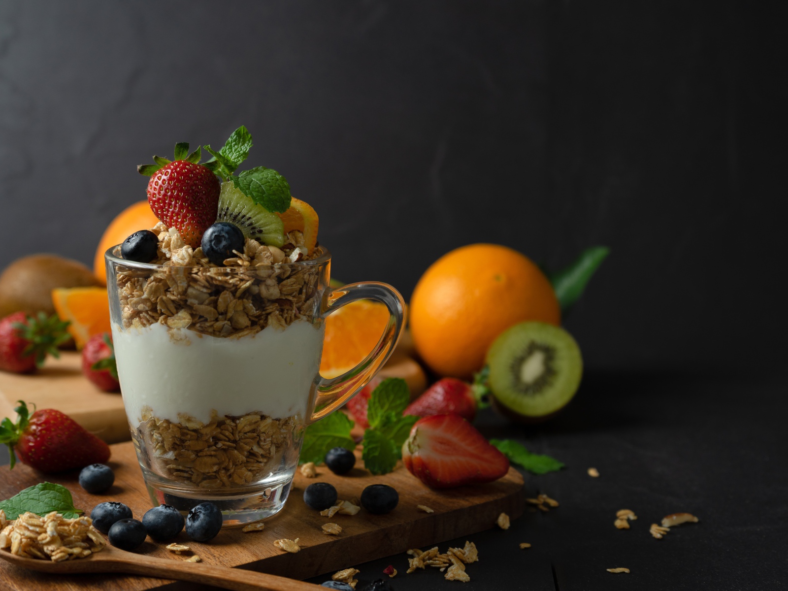 Овсяные хлопья с чашке с йогуртом на столе с ягодами и фруктами