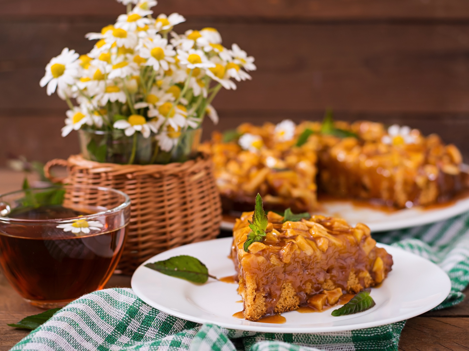 Пирог на столе с чаем и букетом ромашек