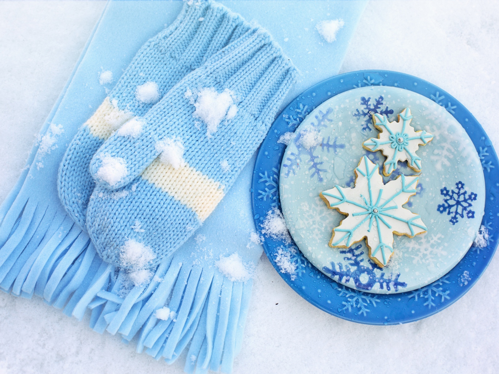 Печенье снежинки на снегу с шарфом и рукавицами