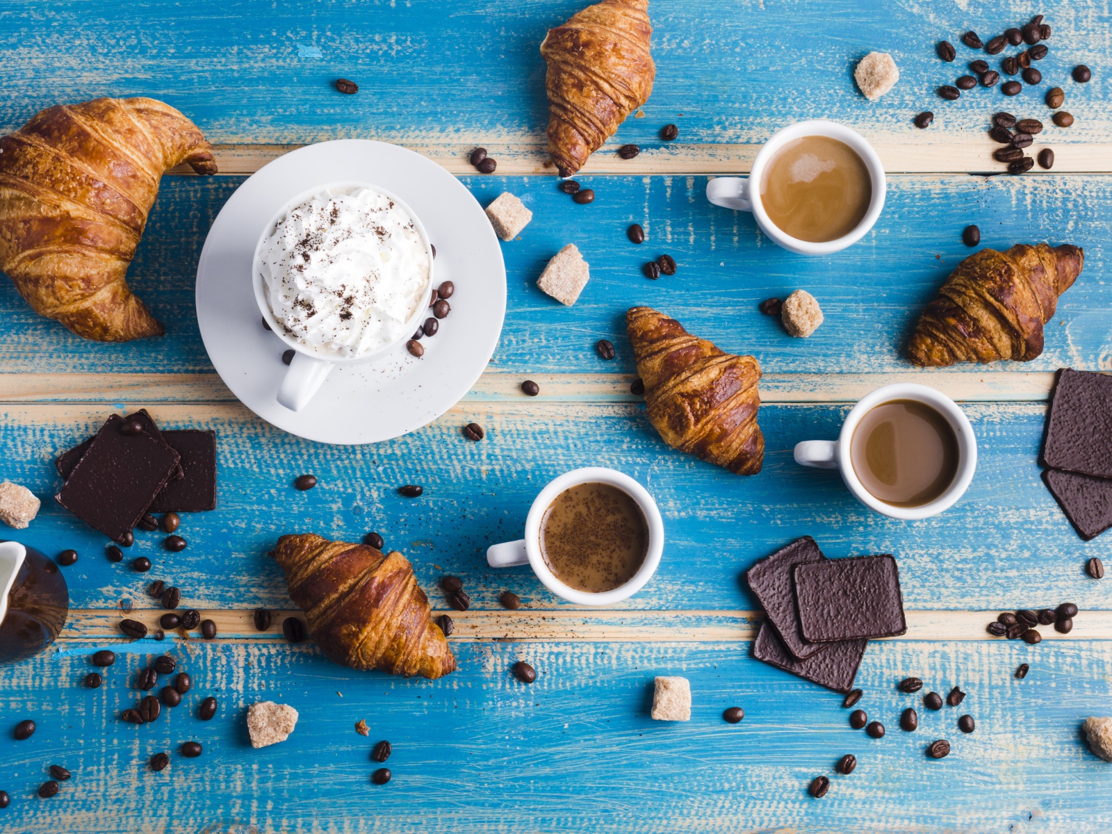 Сладости с кофе на голубом столе