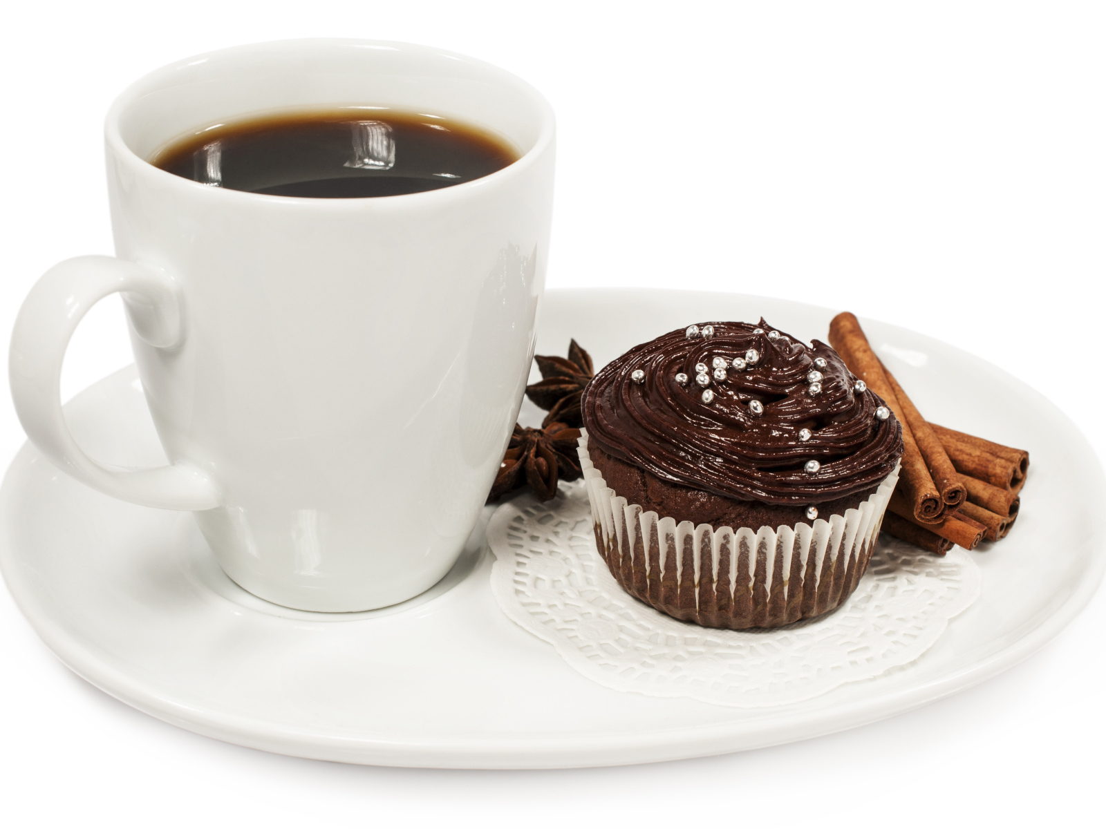 Чашка кофе на белой тарелке с кексом и корицей