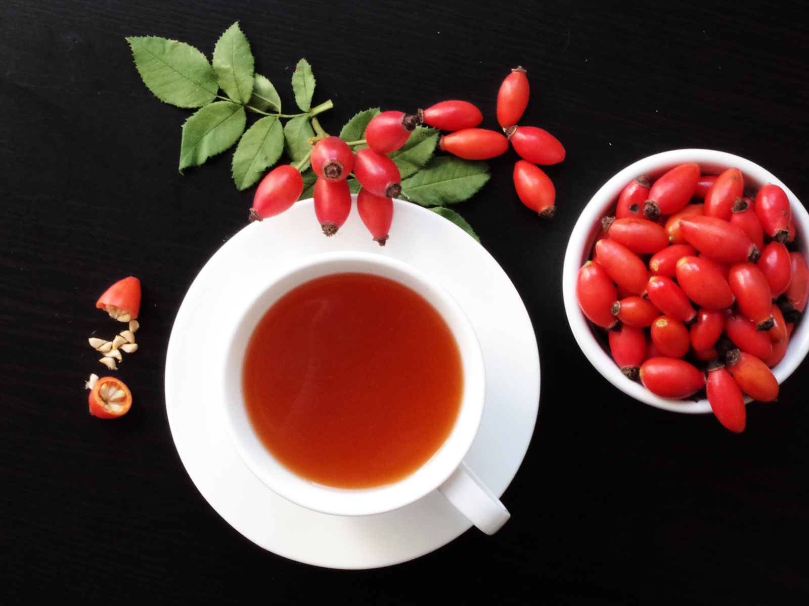 Чашка чая на столе с ягодами шиповника