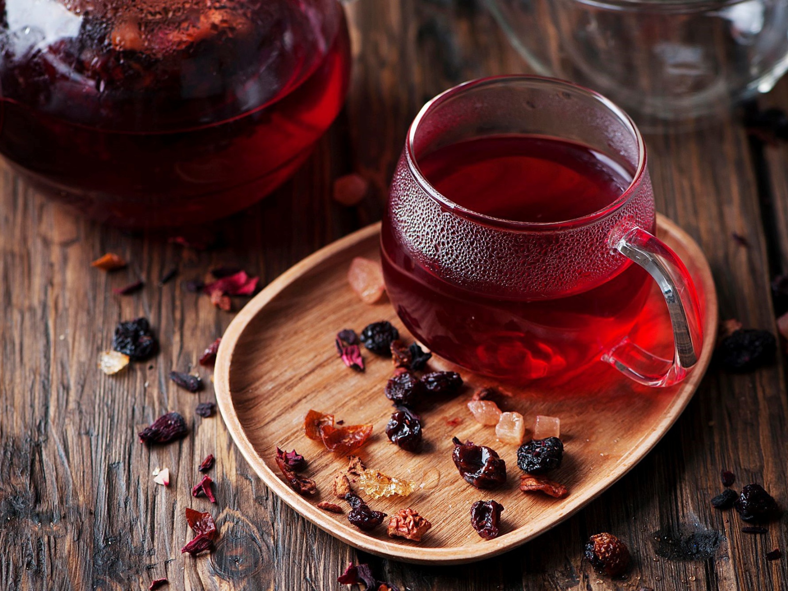 A glass cup of hot red tea with dried fruit