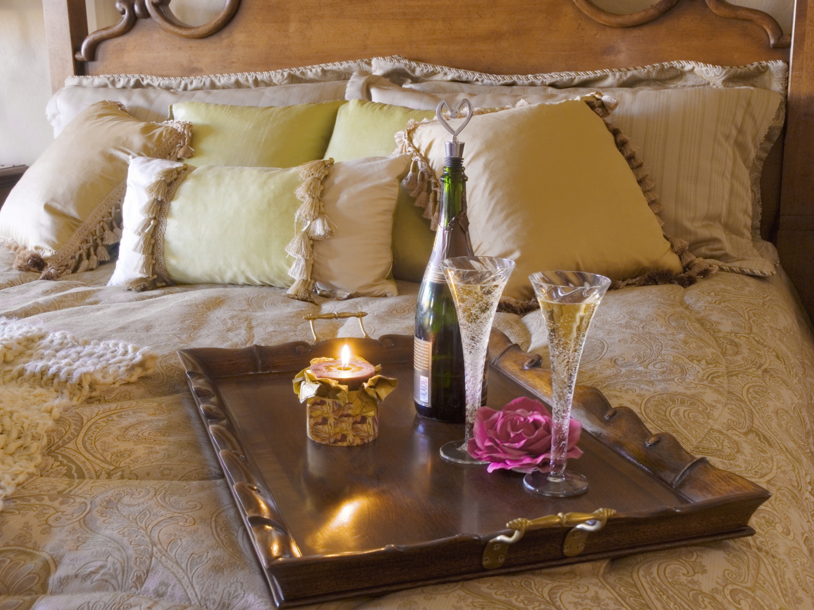 Шампанское с бокалами и свечой на кровати 