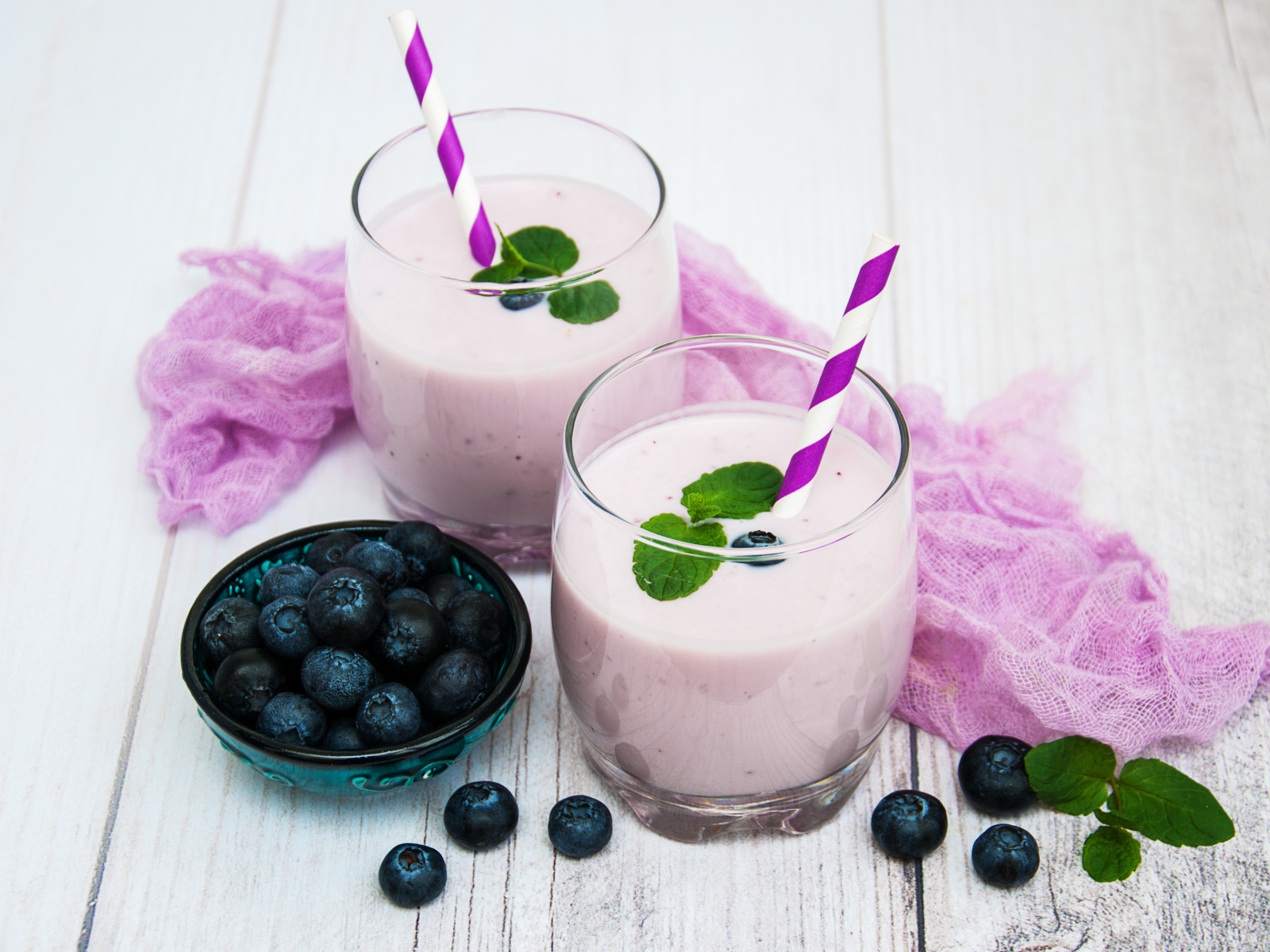 Коктейль в стаканах на столе с ягодами черники