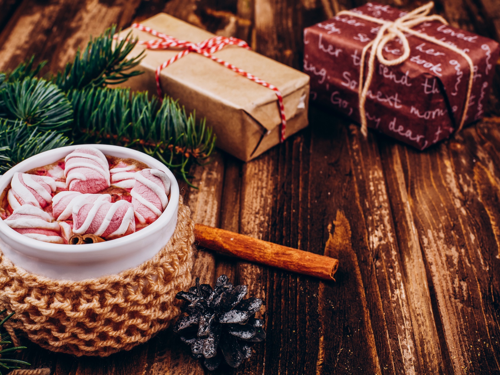 Чашка какао с маршмеллоу на столе с подарками